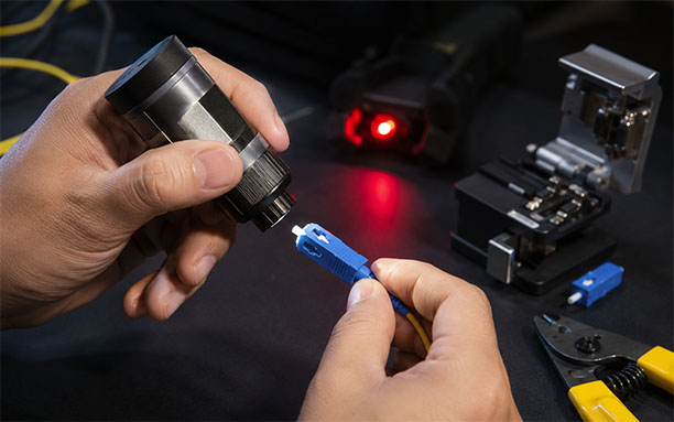 Technician inspecting SC/UPC fast connector end face with fiber inspection microscope