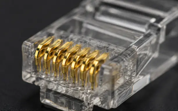 Close-up of gold-plated contact pins inside an RJ45 connector showing prong design
